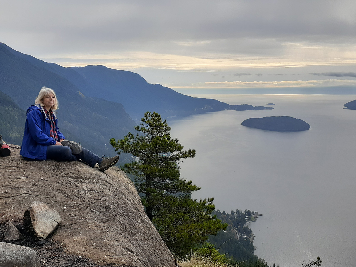 Frances Peck sits at a viewpoint overlooking the water