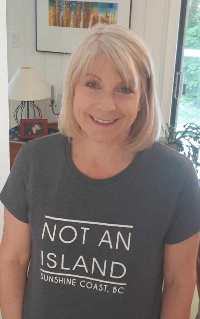 Frances Peck wearing a grey T-shirt that reads "Not an Island: Sunshine Coast BC"