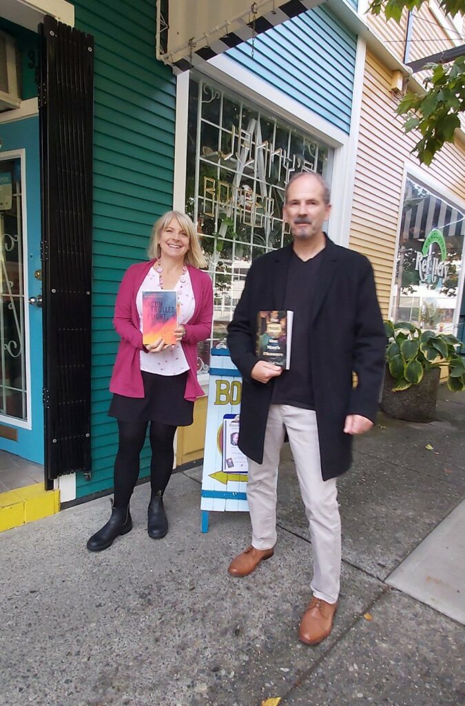 Frances Peck (left) and Danial Neil (right) standing outside Windowseat books holding their novels.
